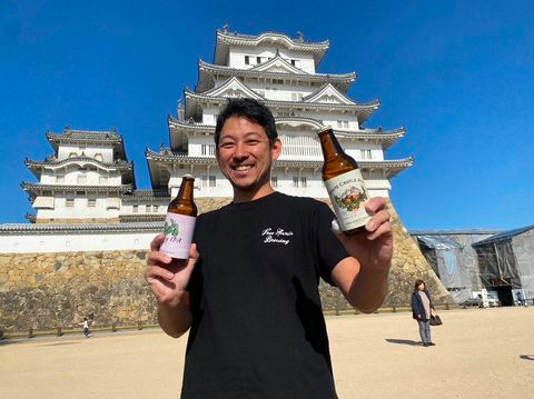 Men Holding Free Spirits Brewing in front of White Castle